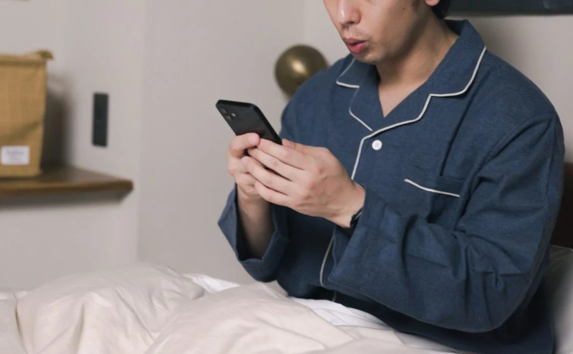 スマホを見て驚く男性の画像