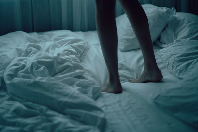 ベッドの上で落ち込んでいる様子の女性の画像